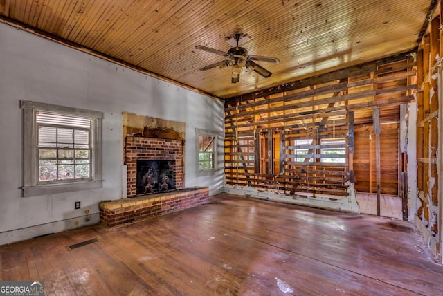 unfurnished living room with hardwood / wood-style flooring, a brick fireplace, ceiling fan, and wood ceiling