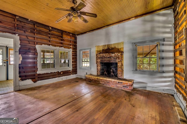 unfurnished living room with ceiling fan, hardwood / wood-style floors, wooden ceiling, and a brick fireplace