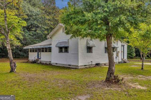 view of side of home with a yard