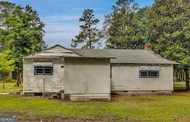 rear view of property featuring a lawn