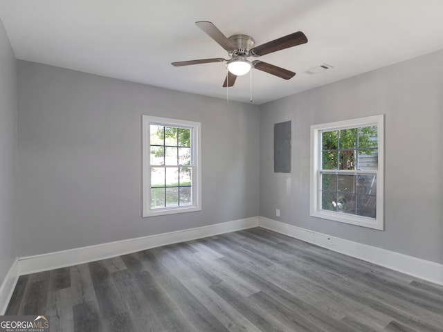 spare room with wood-type flooring, electric panel, and ceiling fan