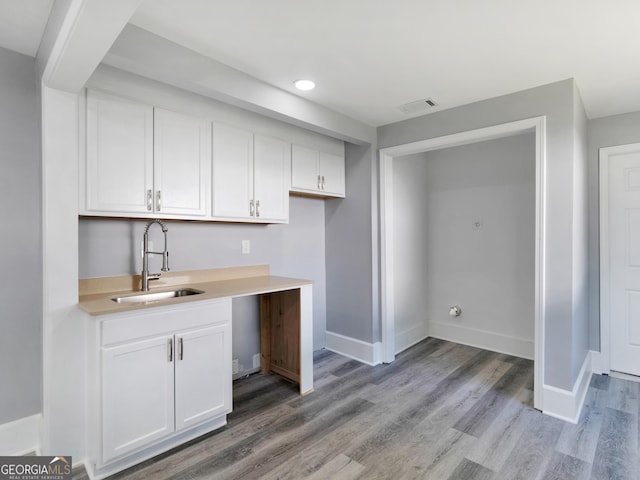 kitchen featuring white cabinets, light hardwood / wood-style floors, and sink