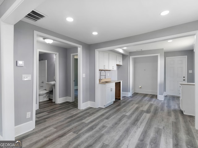 kitchen with white cabinetry, sink, and light hardwood / wood-style flooring