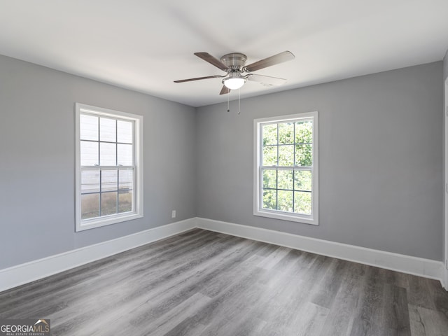 unfurnished room featuring ceiling fan and dark wood-type flooring