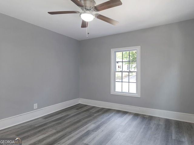 empty room with ceiling fan and dark hardwood / wood-style flooring