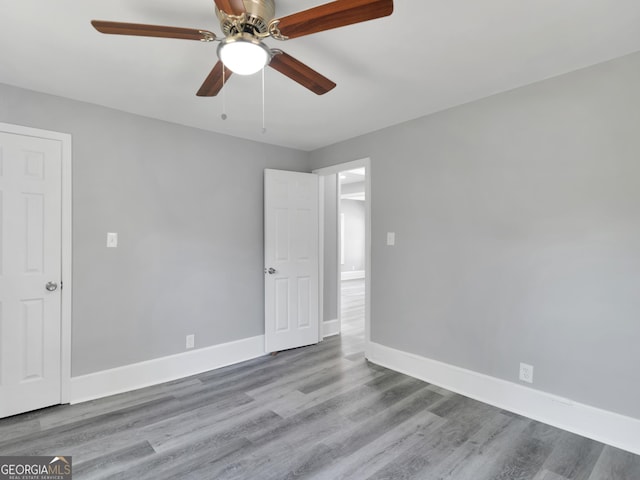 empty room with ceiling fan and light wood-type flooring