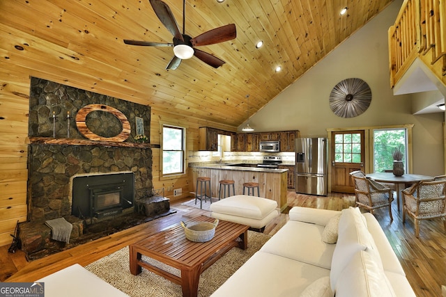 living room featuring high vaulted ceiling, wood ceiling, light hardwood / wood-style floors, and ceiling fan