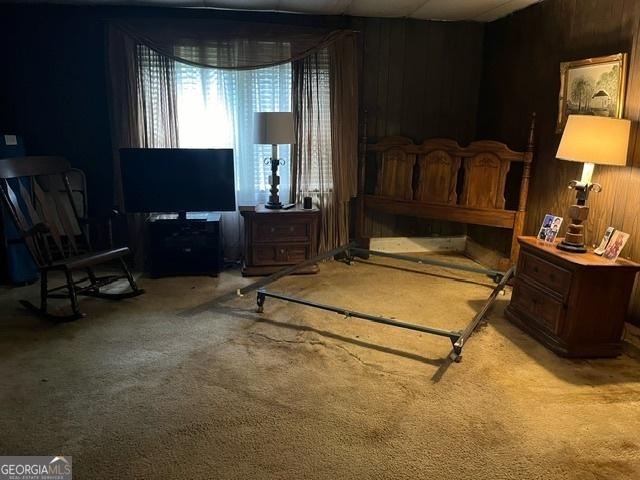 carpeted bedroom with wood walls