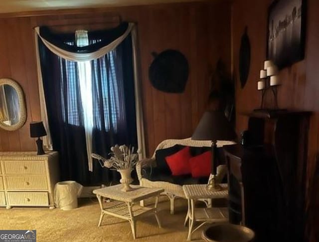 sitting room featuring carpet and wooden walls