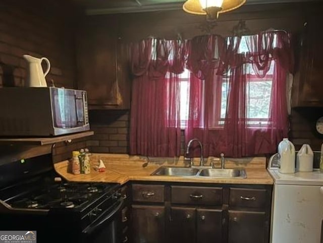 kitchen featuring washer / clothes dryer, black gas stove, and sink