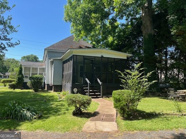 exterior space with a yard and a sunroom