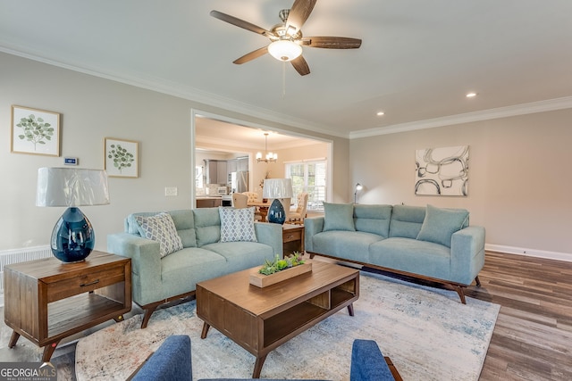 living room with hardwood / wood-style flooring, ceiling fan with notable chandelier, and crown molding