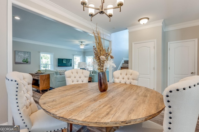 dining area with ceiling fan with notable chandelier and ornamental molding