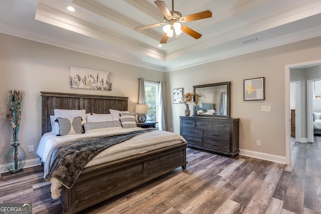 bedroom featuring ceiling fan, dark hardwood / wood-style flooring, a raised ceiling, and ornamental molding