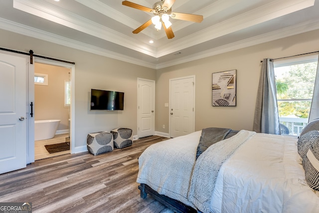 bedroom with ensuite bath, ceiling fan, a raised ceiling, a barn door, and crown molding