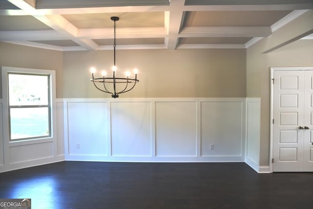 unfurnished dining area featuring dark wood-type flooring, coffered ceiling, crown molding, a notable chandelier, and beam ceiling