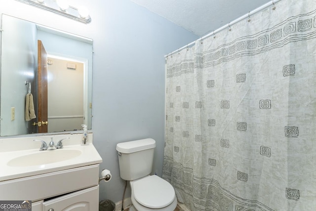 bathroom with a textured ceiling, toilet, and large vanity