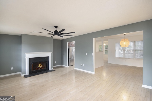 unfurnished living room with ceiling fan and light hardwood / wood-style floors