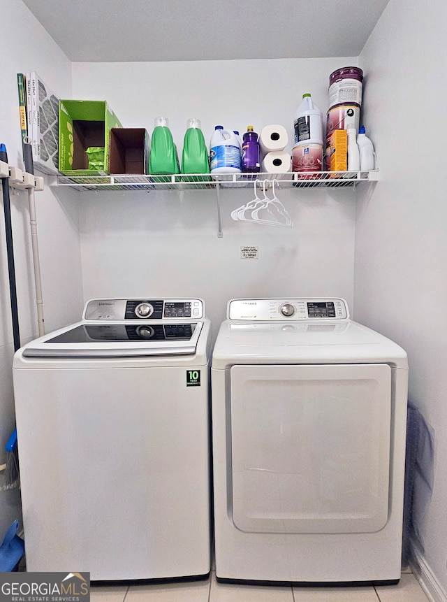 washroom featuring washer and clothes dryer and light tile flooring