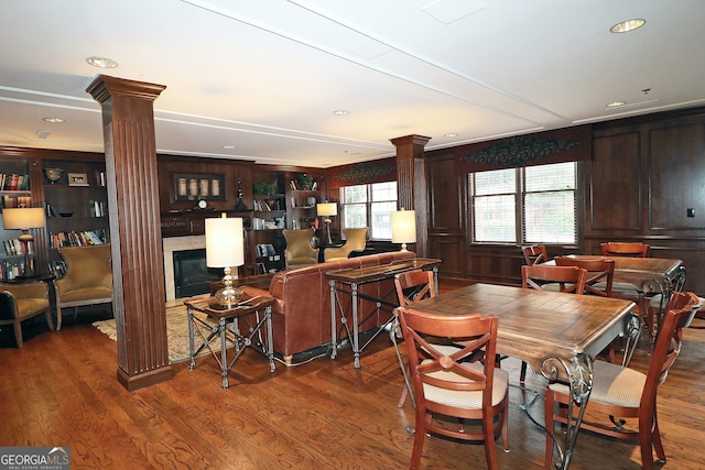 dining space with wood-type flooring, ornate columns, and built in features