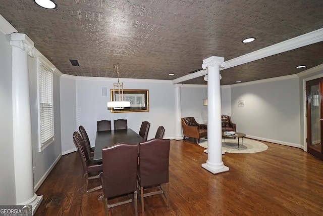 dining area featuring dark hardwood / wood-style flooring, crown molding, and decorative columns