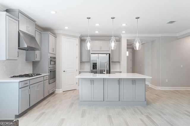 kitchen featuring gray cabinetry, range hood, decorative light fixtures, and appliances with stainless steel finishes