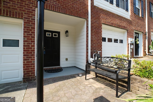 view of exterior entry with covered porch and a garage