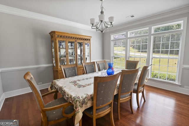 dining space featuring a notable chandelier, dark wood-type flooring, and ornamental molding