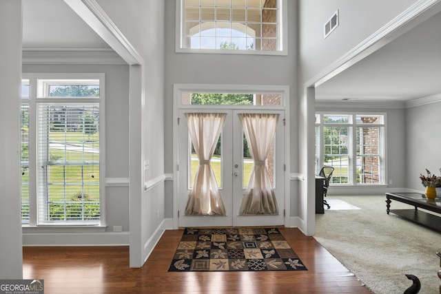 carpeted entryway with french doors and crown molding