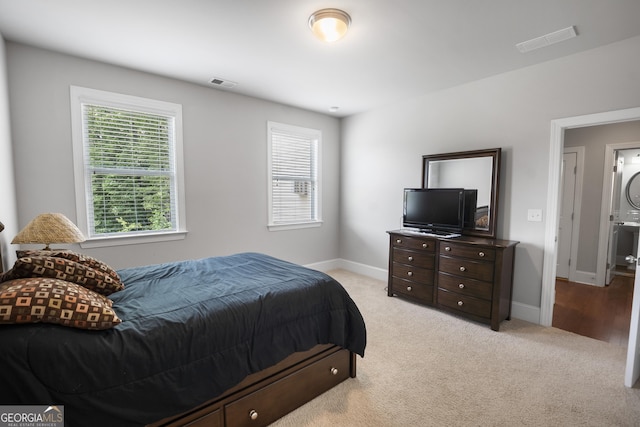 carpeted bedroom featuring stacked washer and clothes dryer