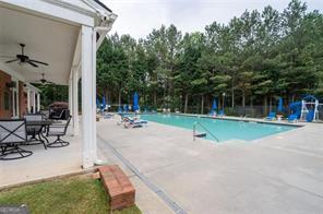 view of swimming pool with ceiling fan and a patio