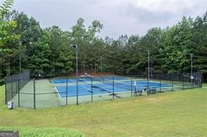 view of tennis court featuring a yard