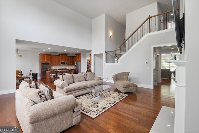 living room with a high ceiling and dark hardwood / wood-style floors