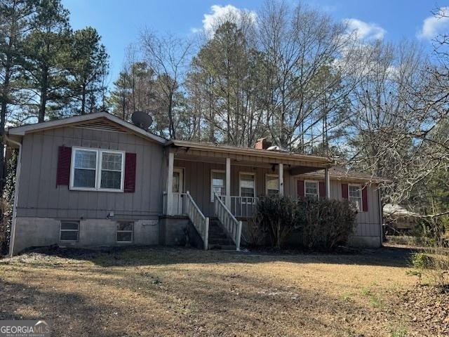 view of front of house with a front yard and a porch