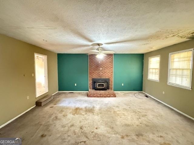 unfurnished living room featuring a textured ceiling and a wood stove