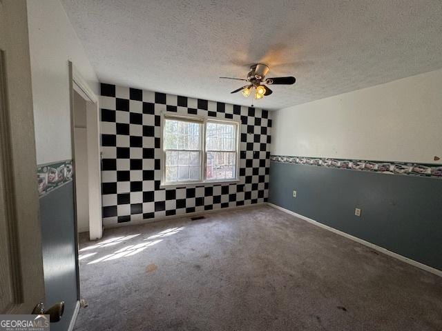 spare room with ceiling fan, carpet floors, and a textured ceiling