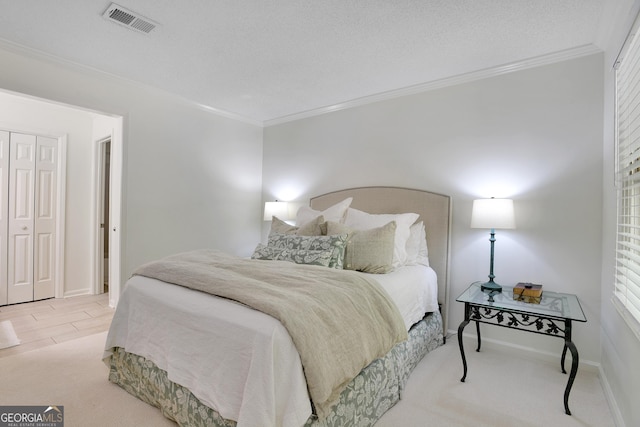 bedroom with crown molding, a closet, light carpet, and a textured ceiling