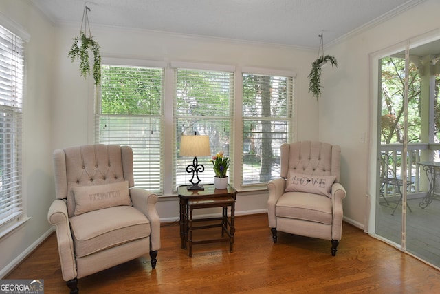 living area with hardwood / wood-style flooring and ornamental molding