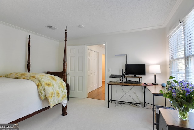 carpeted bedroom with a closet, a textured ceiling, and ornamental molding