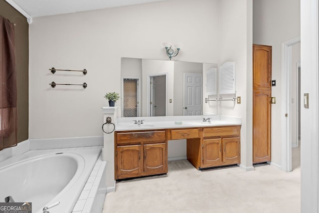 bathroom with tiled tub, vanity, and a textured ceiling