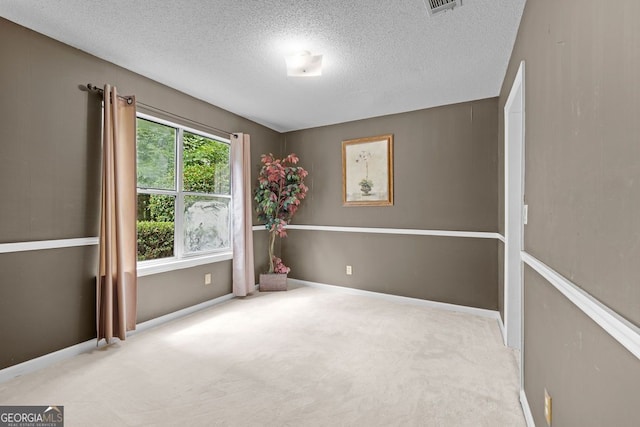 unfurnished room featuring carpet and a textured ceiling