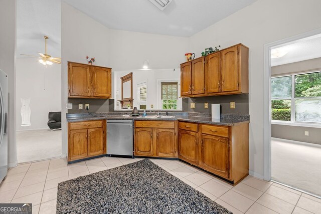 kitchen with light carpet, stainless steel dishwasher, sink, high vaulted ceiling, and ceiling fan