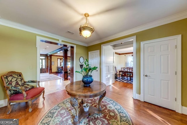 interior space with crown molding and light wood-type flooring