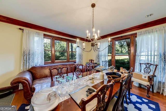 dining room with wood-type flooring, crown molding, a wealth of natural light, and a chandelier