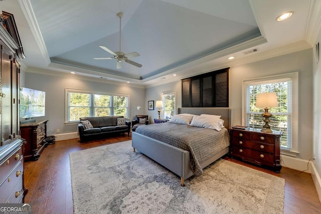 bedroom with crown molding, ceiling fan, dark hardwood / wood-style floors, and a raised ceiling