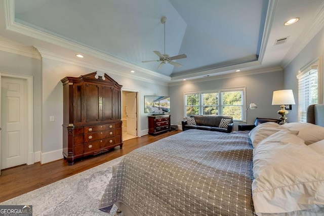 bedroom featuring multiple windows, crown molding, dark wood-type flooring, and a raised ceiling