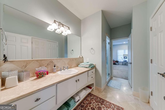 bathroom featuring tile patterned flooring, vanity, an inviting chandelier, and decorative backsplash