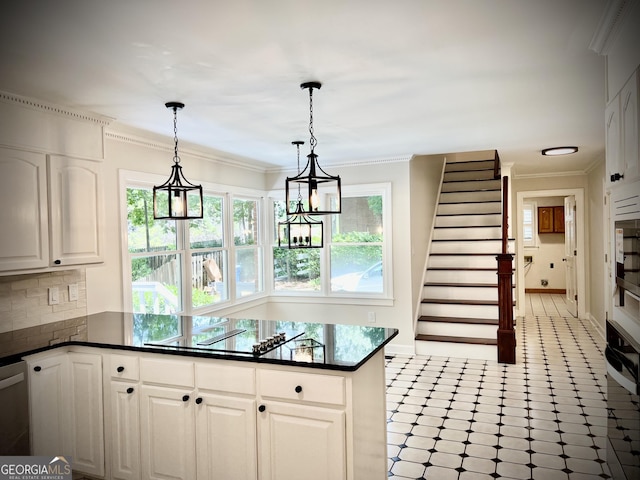 kitchen with decorative light fixtures, white cabinets, decorative backsplash, and plenty of natural light