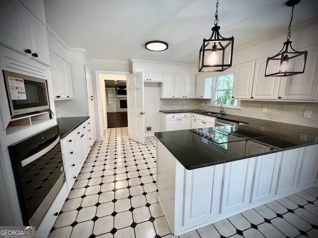 kitchen featuring decorative light fixtures, sink, white cabinetry, and stainless steel appliances