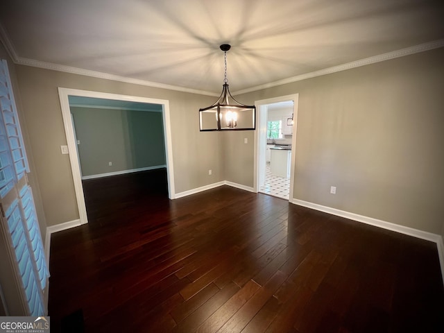 unfurnished dining area featuring dark wood-type flooring, a notable chandelier, and ornamental molding